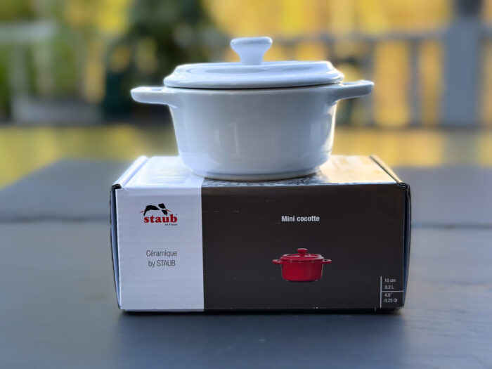 A white Staub Mini Cocotte sitting on its box outside